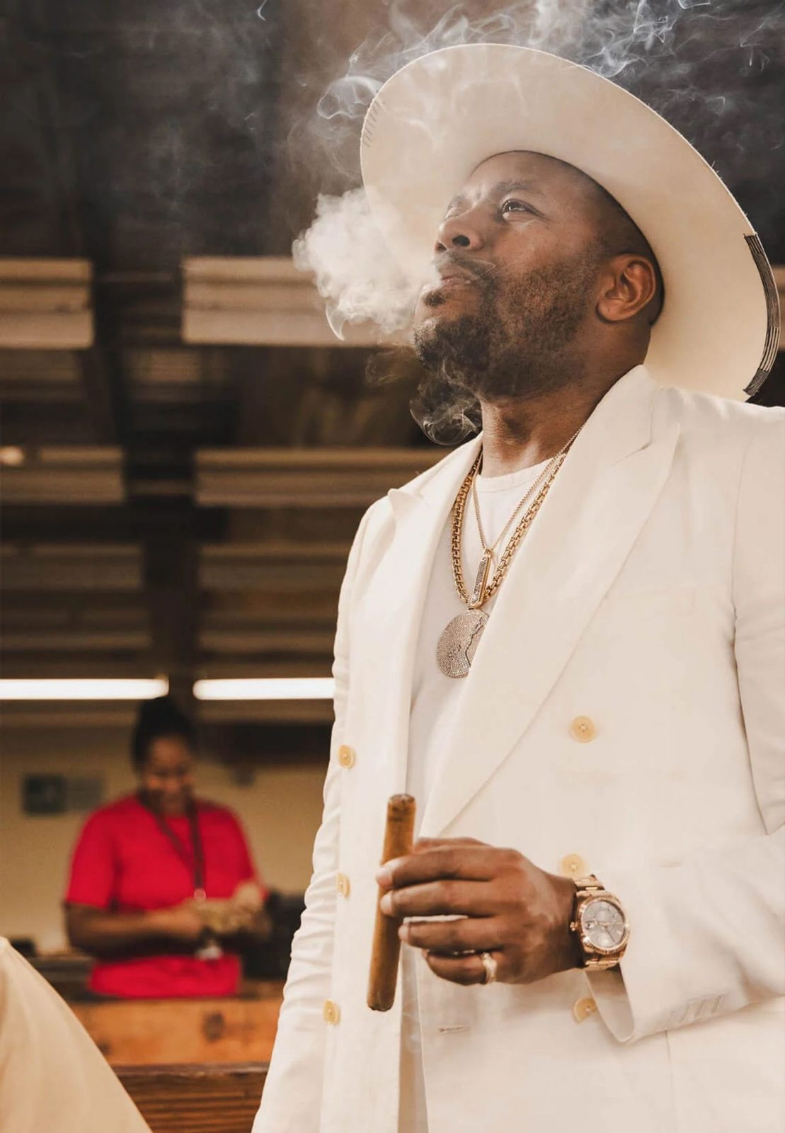 D-Nice smoking a cigar at a tobacco production facility