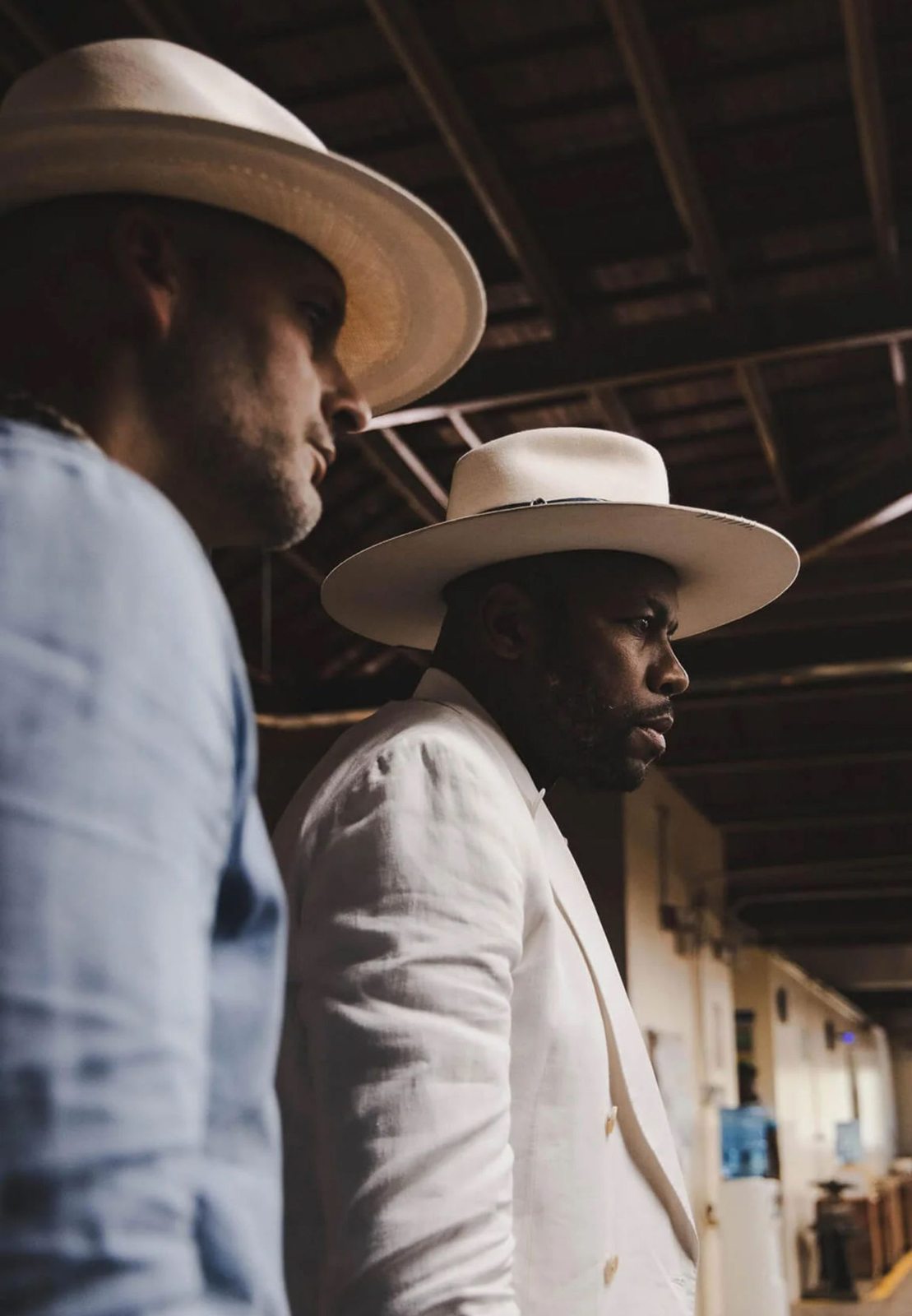 D-Nice and another man in hats at a tobacco production facility